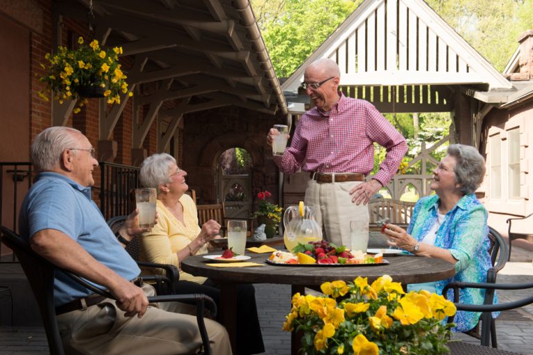 Four seniors enjoying lemonade at a table