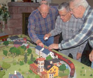 Cornwall Manor residents and members of the Railroad Club work on the layout