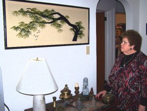Resident Sally Renda with a piece of Chinese embroidery and items from China