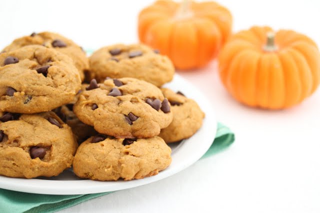 pumpkin chocolate chip cookies stacked on a plate