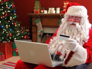 Santa shopping online from home looking at a credit card