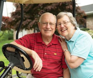 Dave and Marcie Orledge, Cornwall Manor residents, sitting together on a golf cart.