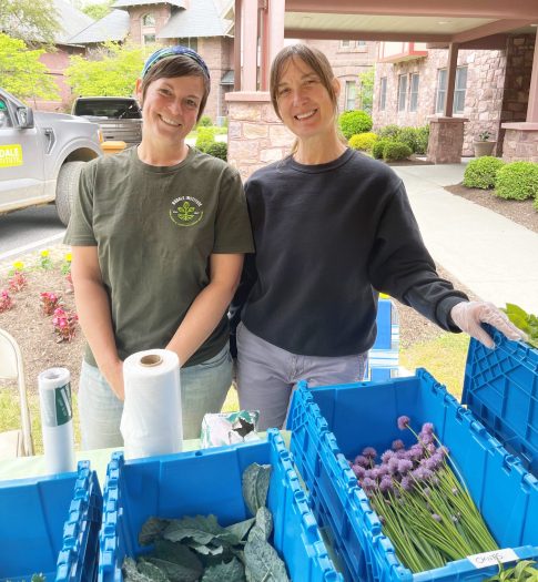 Katie Landis and Dina Thalen working at a Friday Farm Market.